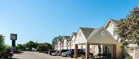 A row of single-story motel buildings with a sign for Quality Inn.