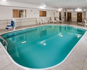 A swimming pool with a tiled deck, lounge chairs, and a changing room. - Quality Inn near Northtown Mall & National Sports Center (Coon Rapids)