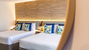 A hotel room with two beds, a wooden headboard, and floral-patterned pillows. - Paradise Resort Gold Coast (Surfers Paradise)
