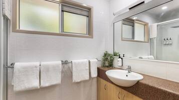 Une salle de bain moderne avec un grand miroir, un lavabo et un porte-serviettes.
