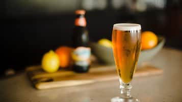 A glass of beer on a bar counter with a blurred background.