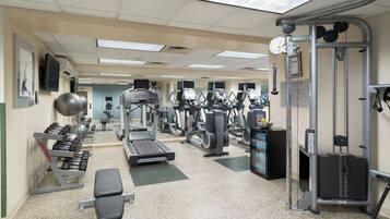 A gym with treadmills, weight machines, and free weights.