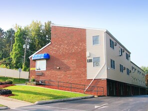 A two-story building with a brick facade and a blue awning labeled "Rodeway Inn."