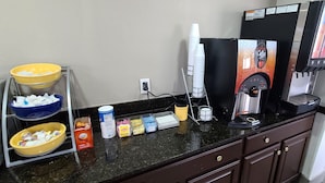 A coffee station with a coffee machine, cups, and condiments. - Red Roof Inn & Suites Duncan (Duncan)