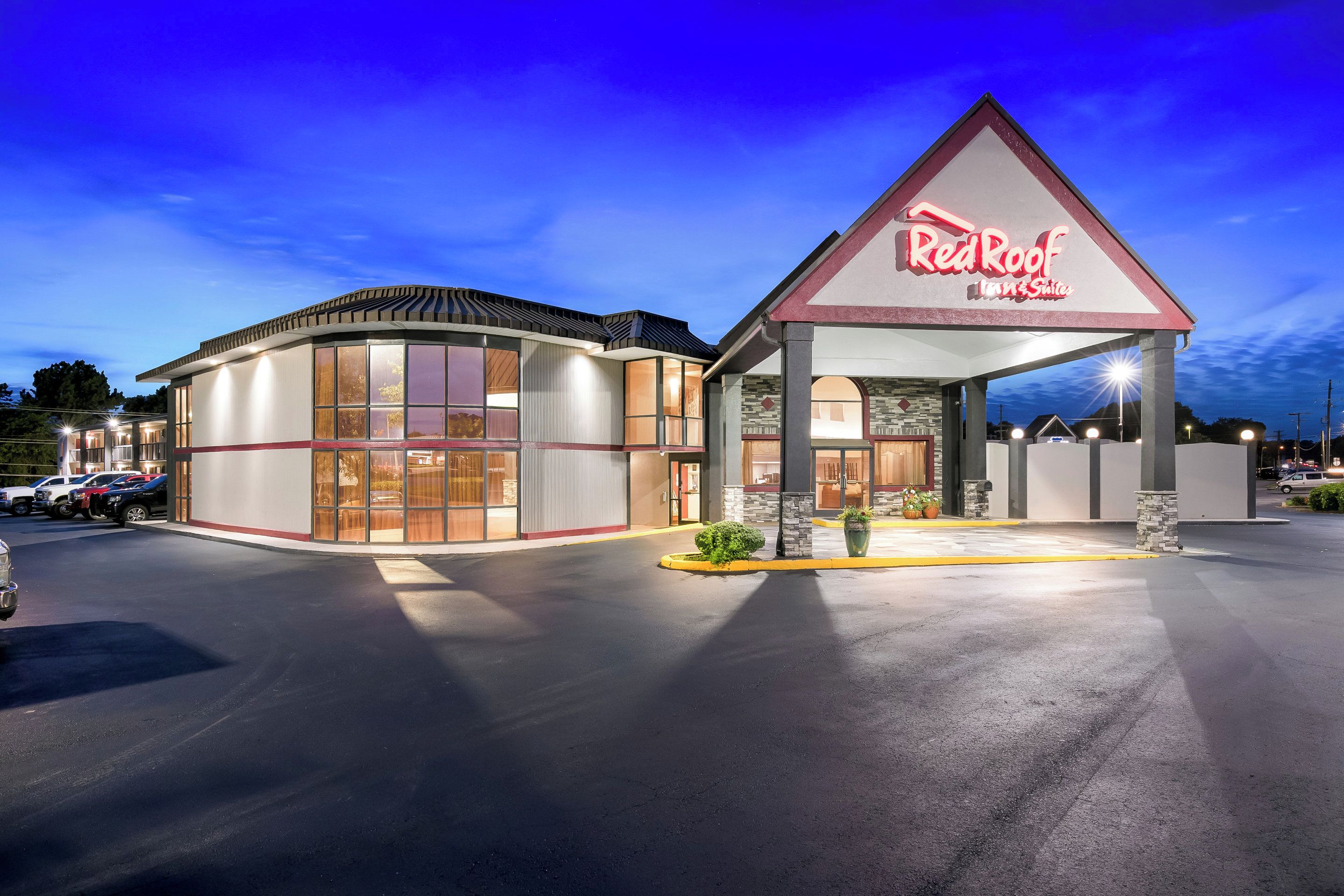 Un hôtel Red Roof Inn & Suites doté d’un grand parking et d’une entrée bien éclairée.