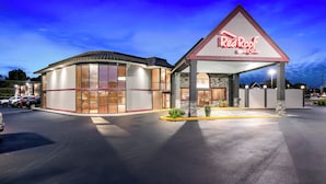 A Red Roof Inn & Suites with a large parking lot and a well-lit entrance. - Red Roof Inn & Suites Duncan (Duncan)