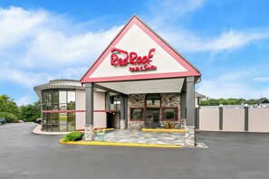 A Red Roof Inn & Suites building with a modern design, featuring a prominent red and white color scheme, large windows, and a spacious parking area. - Red Roof Inn & Suites Duncan (Duncan)