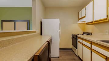 A compact kitchen with a refrigerator, stove, and dishwasher.