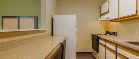 A compact kitchen with a refrigerator, stove, and dishwasher.