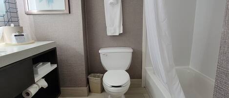 A modern bathroom with a toilet, sink, and bathtub.