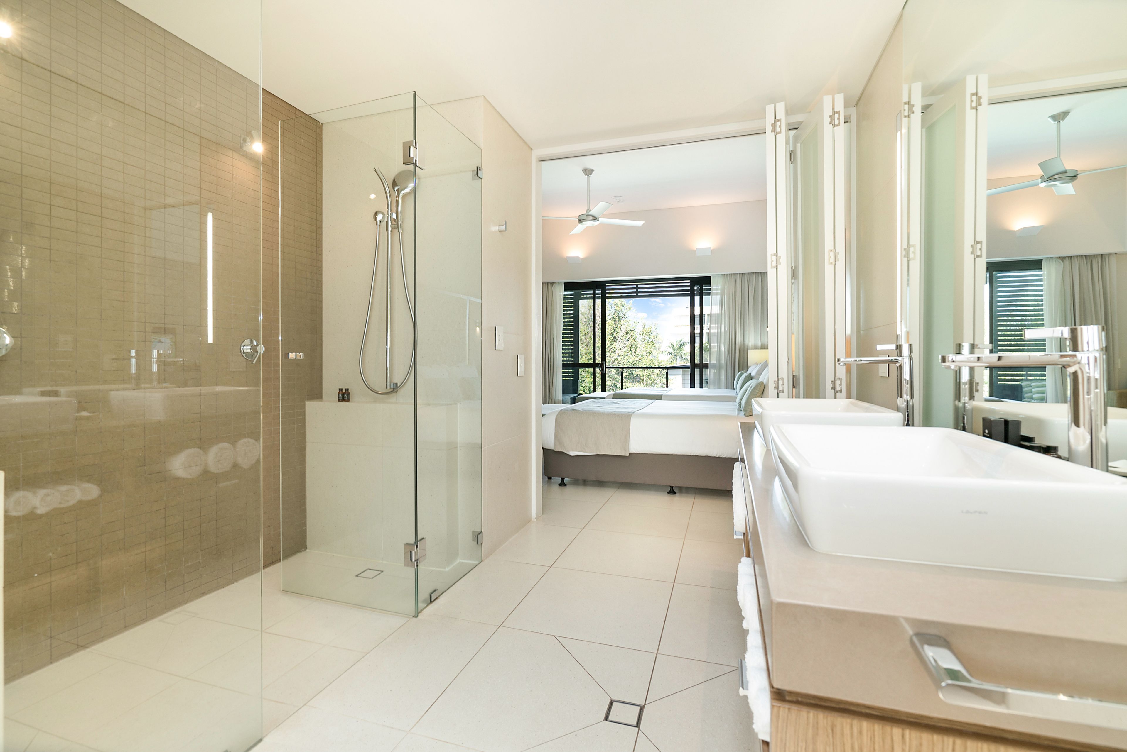 A modern bathroom with a glass-enclosed shower, a large bathtub, and a separate shower area.