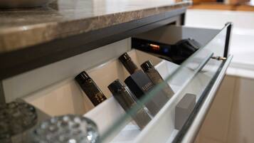 A bathroom with a glass shelf holding toiletries and a white sink.