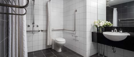 A modern bathroom with a toilet, shower, and sink.