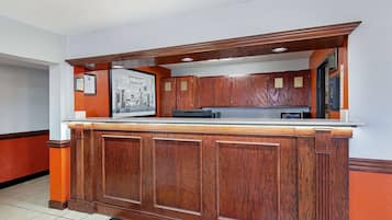 A kitchen area with wooden cabinets, a countertop, and a tiled floor.
