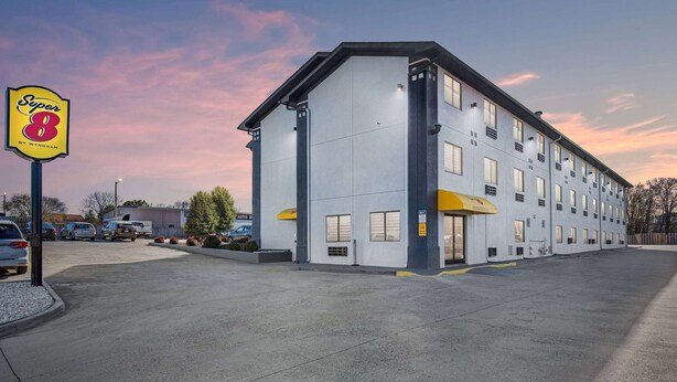 A multi-story hotel with a flat facade, large windows, and a yellow awning. - Super 8 by Wyndham Johnson City (Johnson City)