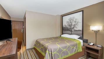 Une chambre d’hôtel avec un lit, une télévision, un bureau et une lampe.