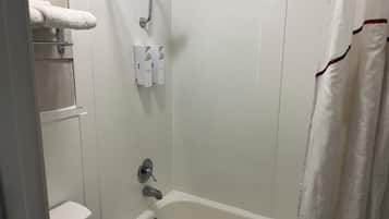 A bathroom with a bathtub, a showerhead, and a toilet.