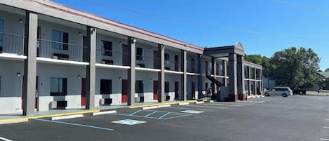 A motel with multiple floors, a covered walkway, and a parking lot.