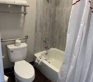 A bathroom with a toilet, a bathtub, and a shower curtain. - Red Roof Inn Kimball, TN - I-24 (Jasper)