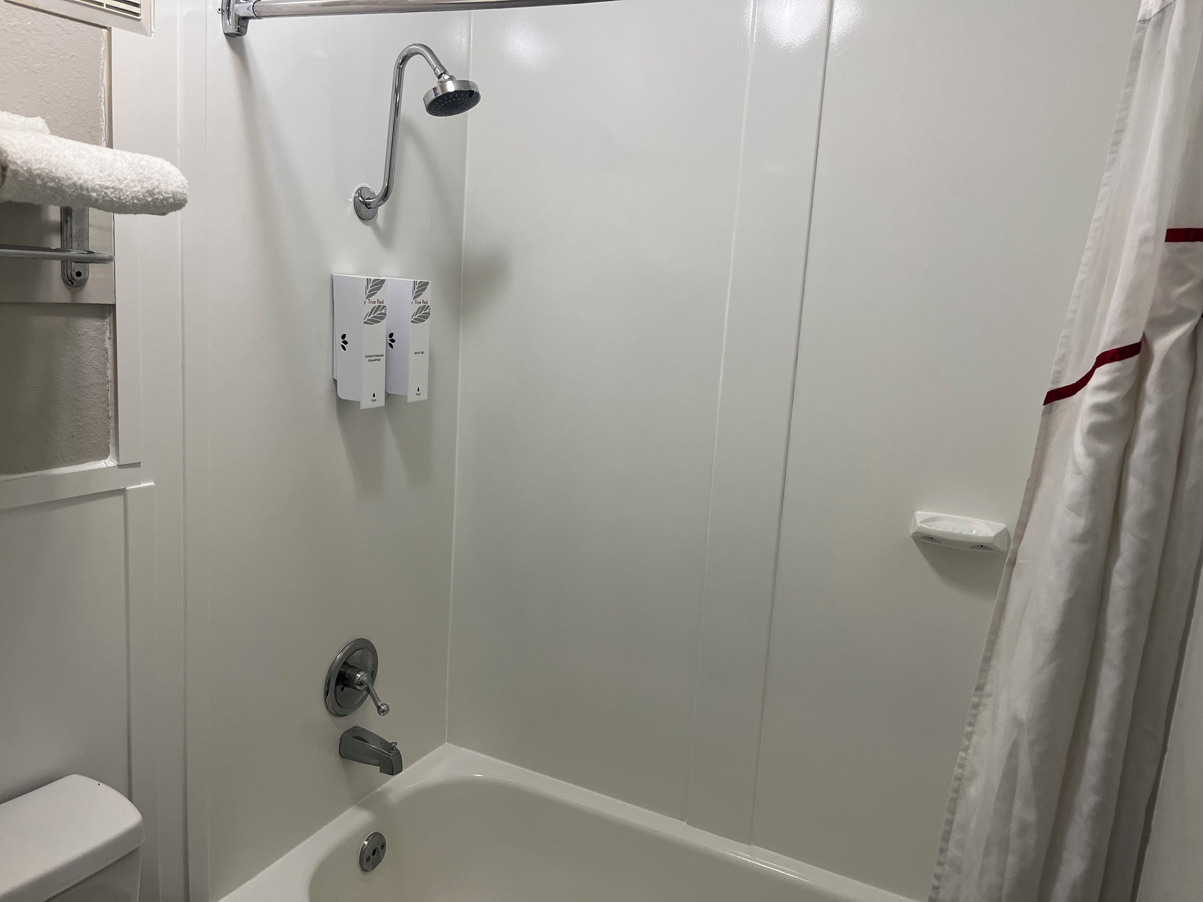 Um banheiro com banheira, chuveiro e porta-toalhas.