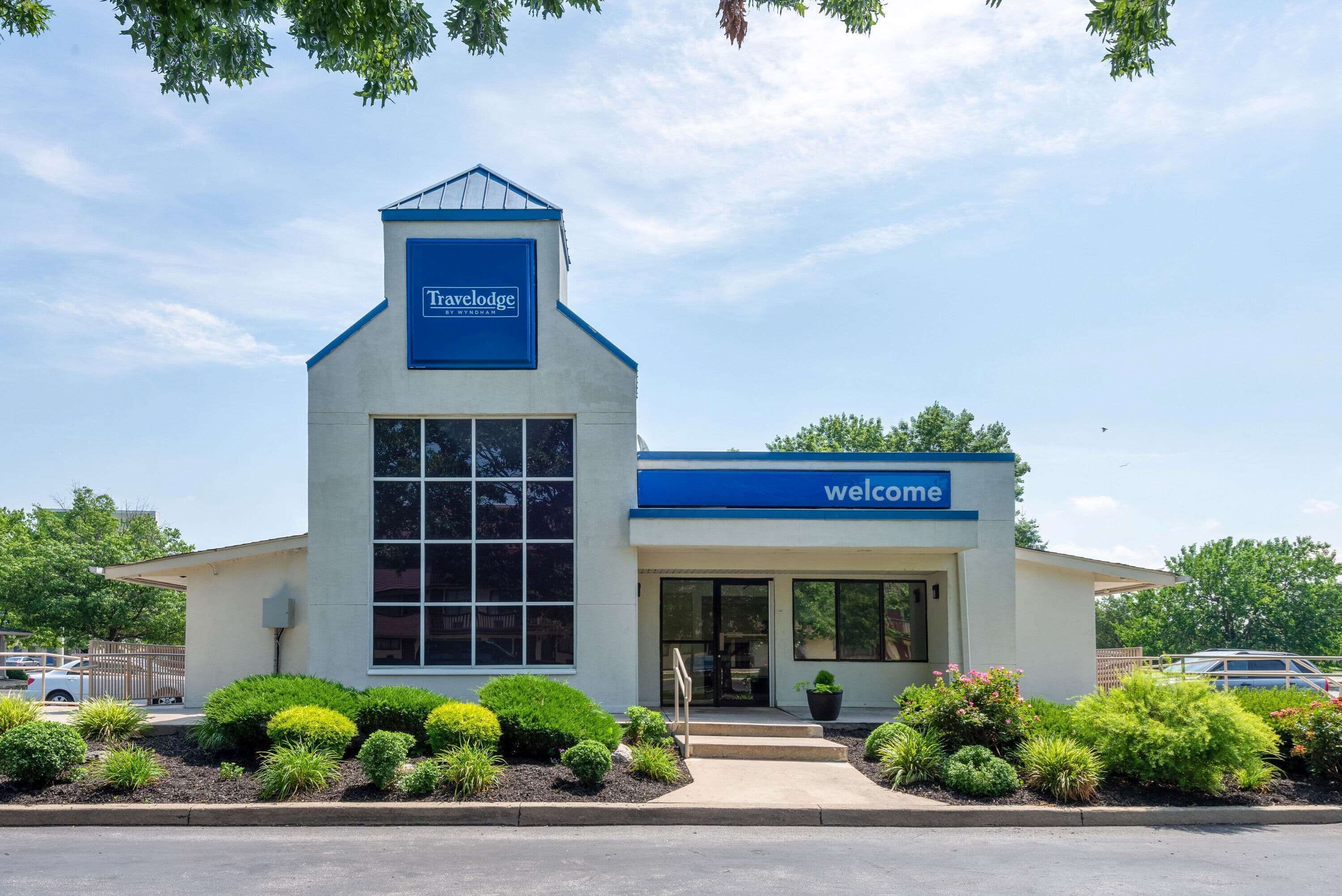 A Travelodge hotel with a welcoming entrance, a large window, and a blue sign.