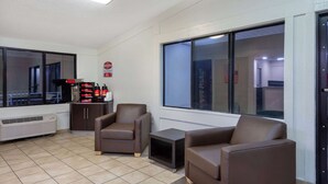 Una habitación amoblada con un ventanal grande, un calefactor y un armario con botellas.