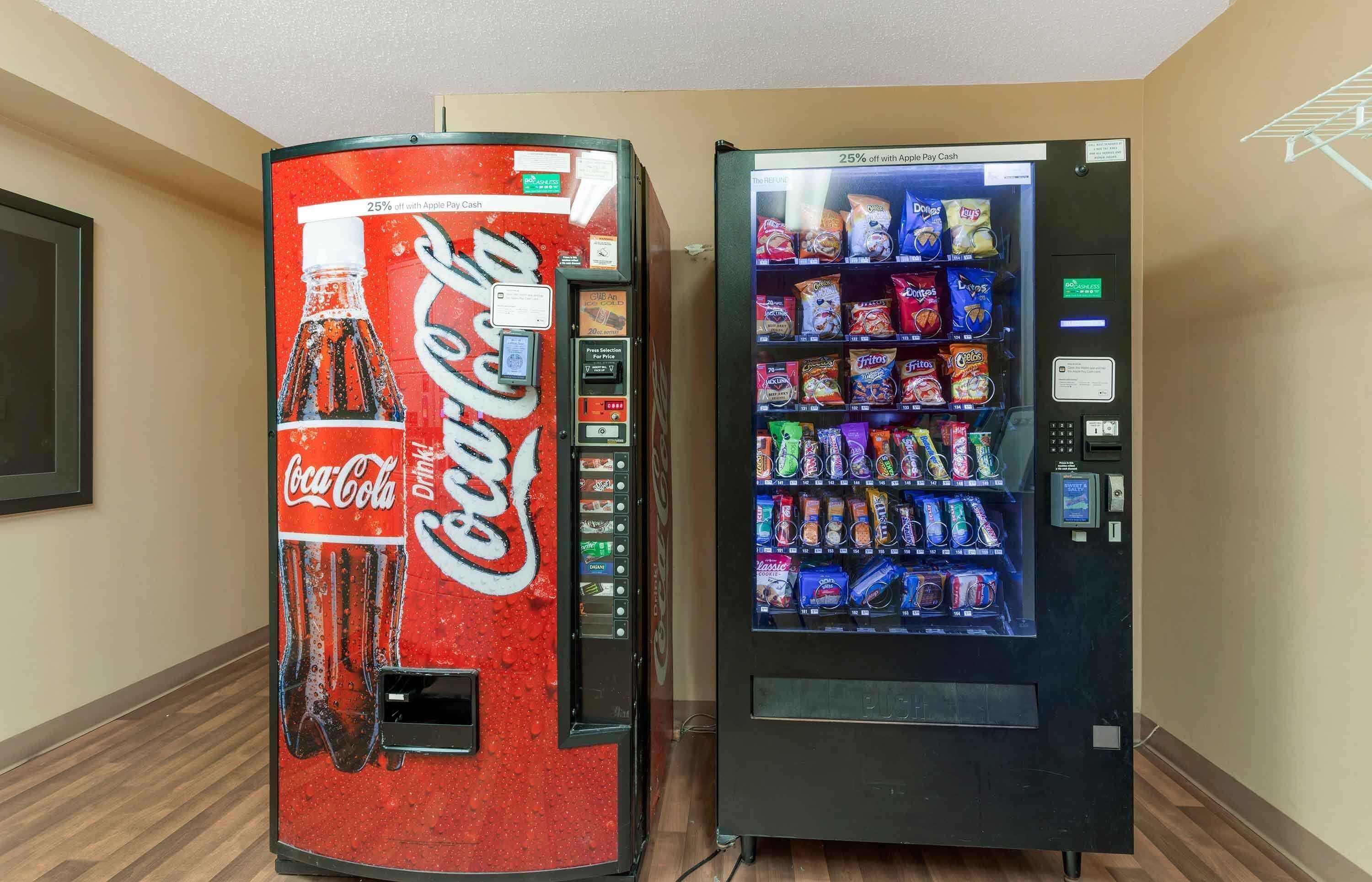 Two vending machines, one Coca-Cola branded and one offering snacks and drinks.