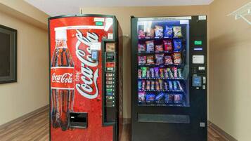 Two vending machines, one Coca-Cola branded and one offering snacks and drinks.