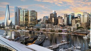 A city skyline with modern skyscrapers, a marina with boats, and a distinctive curved building. - ibis Sydney Darling Harbour (Sydney)
