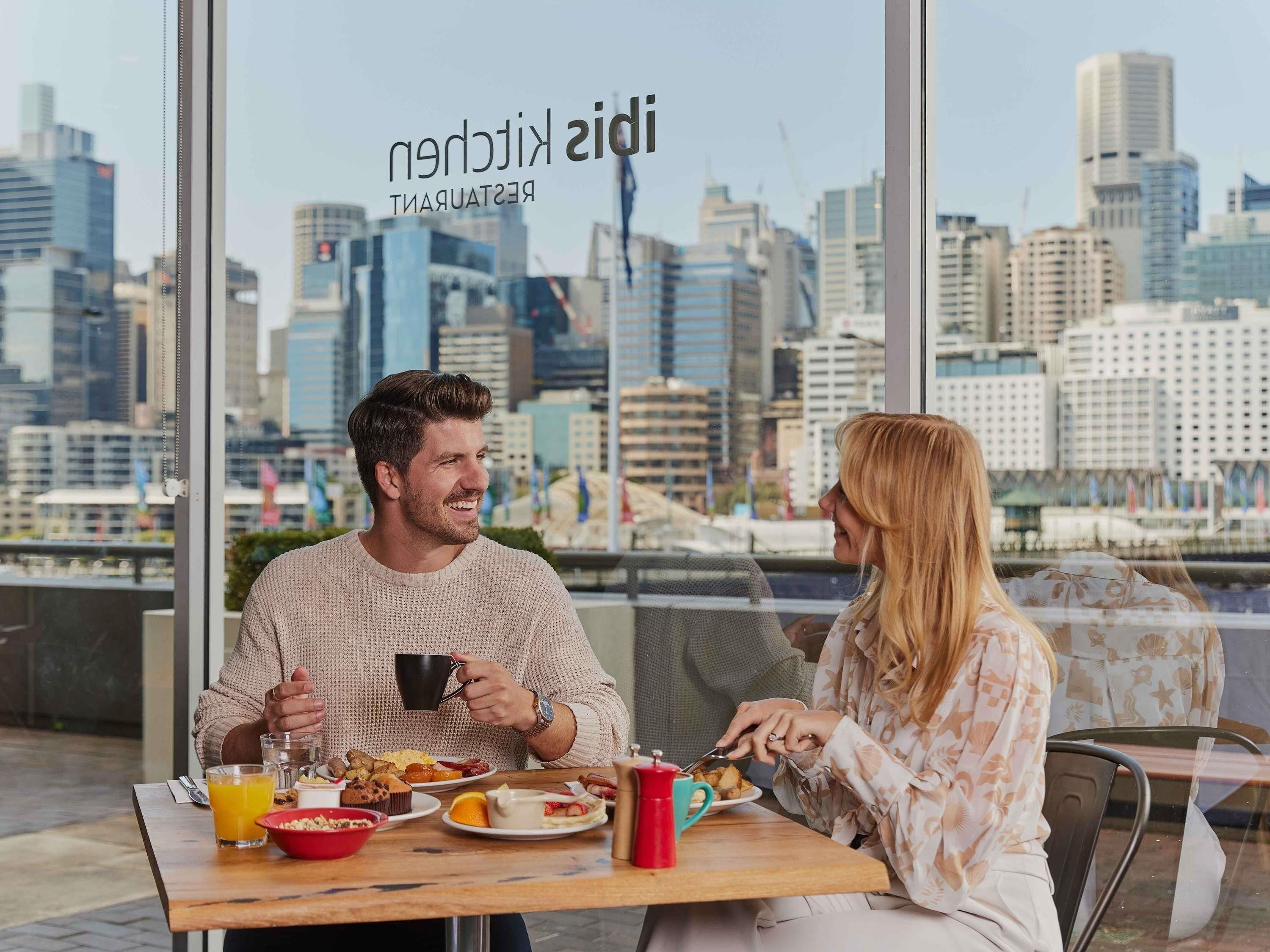 A breakfast setting with a city view, a table with food and drinks, and a sign reading 'KIDS RESTAURANT'.