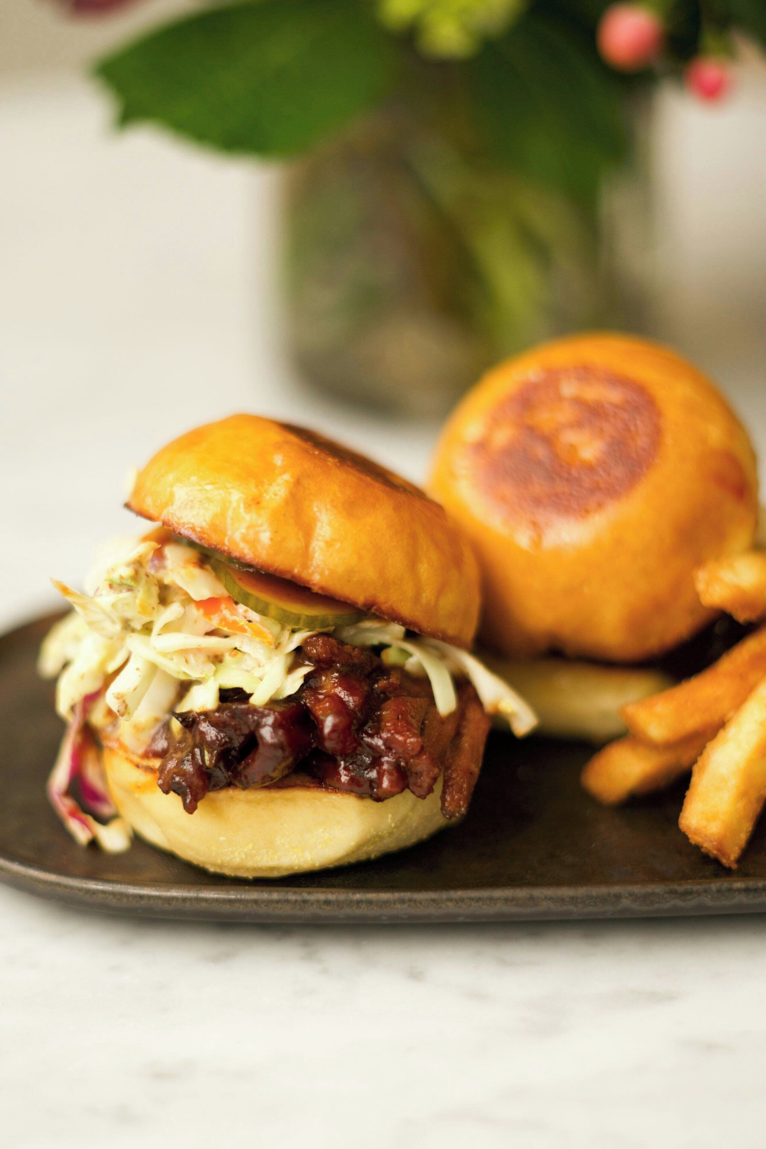 A sandwich with coleslaw and a side of fries on a plate.