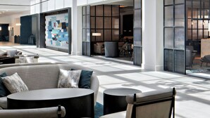 A spacious lobby with a high ceiling, modern pendant lighting, comfortable seating, and large windows allowing natural light. - Sheraton Dallas Hotel (Dallas)