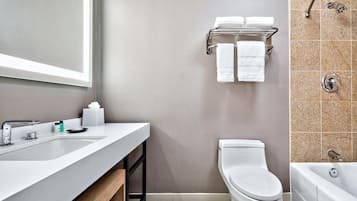 A modern bathroom with a white sink, a toilet, and a bathtub.