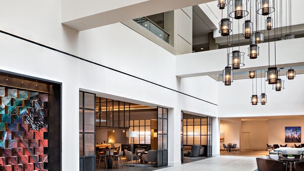 A spacious lobby with a high ceiling, modern lighting fixtures, and a seating area with sofas and tables. - Sheraton Dallas Hotel (Dallas)