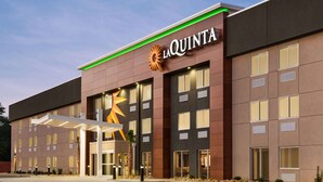 Un hôtel moderne, reconnaissable à son grand panneau « La Quinta », à ses larges fenêtres et à son entrée abritée.
