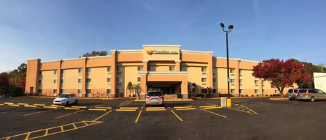 Un hotel Comfort Inn con estacionamiento y cielo despejado.