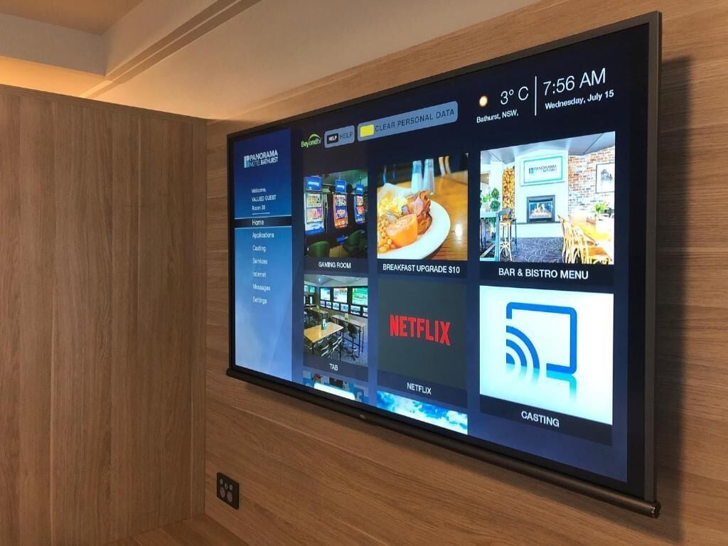 A digital display with various hotel amenities including a gaming room, breakfast upgrade, and a bar & restaurant menu.