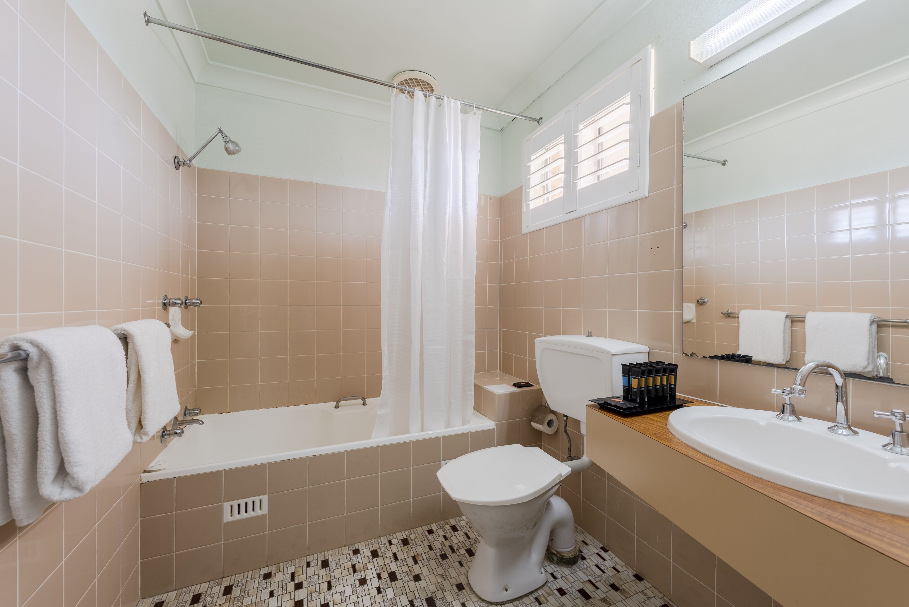 Un baño con bañera, inodoro, lavabo y cortina de ducha.