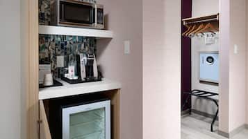 Cocina compacta equipada con microondas, cafetera y refrigerador pequeño.