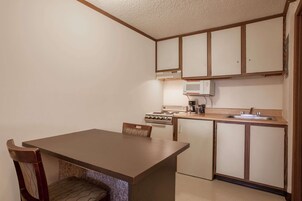 Cocina compacta con comedor, que incluye estufa, microondas y lavaplatos.