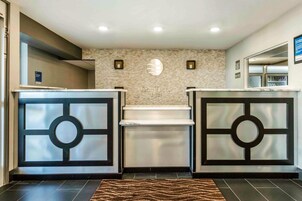 Un área de recepción con pared de piedra, una chimenea central y dos mostradores con diseños circulares.