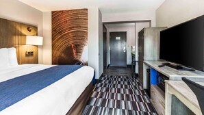 A hotel room with a bed, a TV, a desk, and a bathroom visible through an open door. - Comfort Inn Memphis Airport West (Memphis)