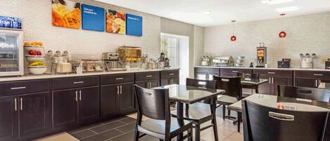 A modern kitchen area with dark cabinets, a coffee machine, and a breakfast bar.