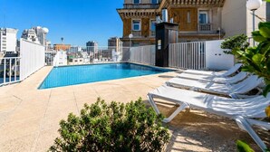 A rooftop pool with lounge chairs, surrounded by buildings and a clear sky. - Feir's Park Hotel (Buenos Aires)