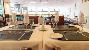 Ein Restaurant mit gedeckten Tischen, ausgestattet mit weißen Tischdecken, klarem Glas und ordentlich gefalteten Servietten.