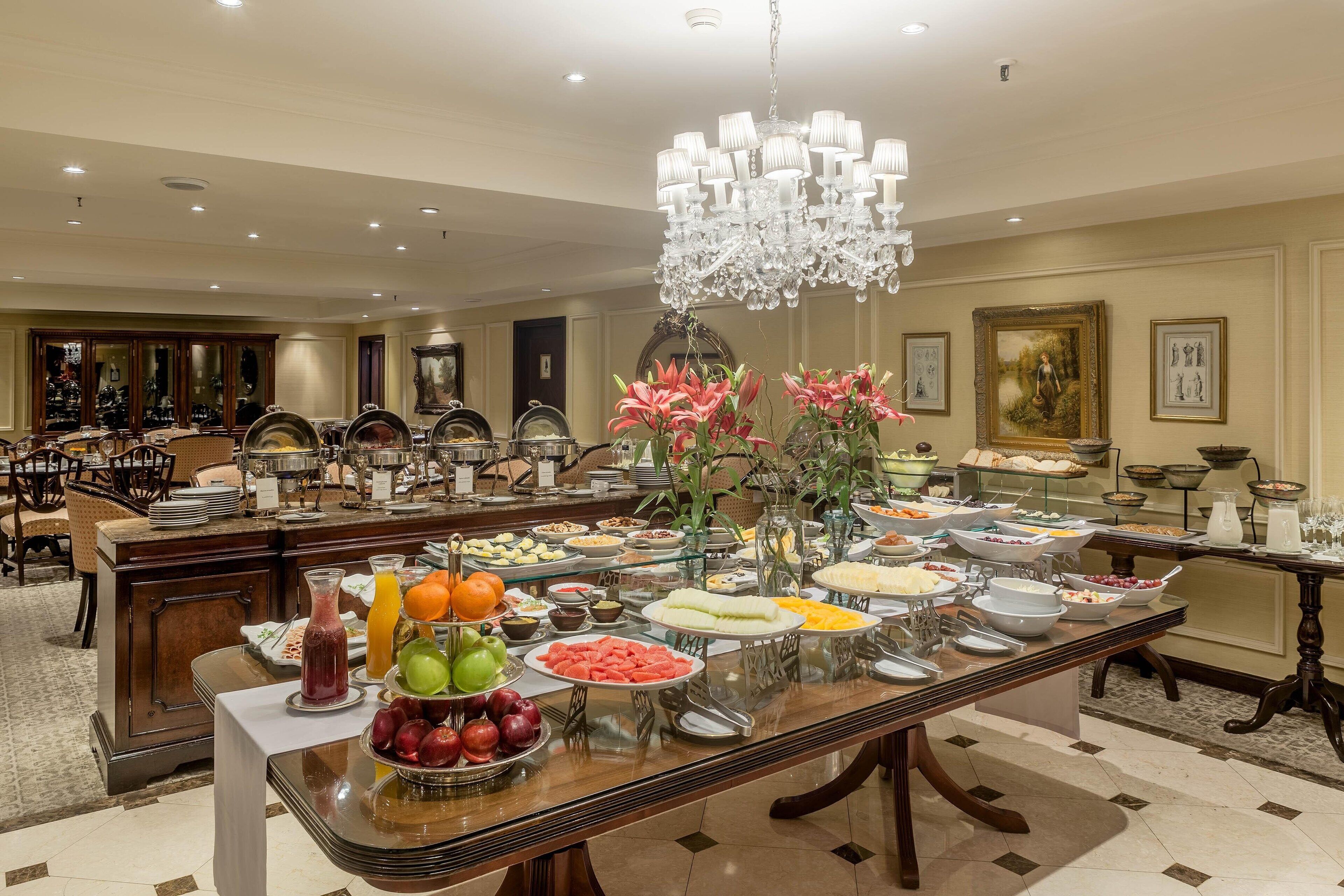 A buffet setup with various food items and a chandelier.