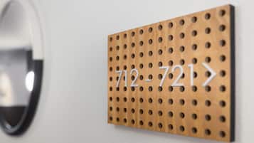 A wooden wall-mounted sign with the numbers "712-721" and a directional arrow.