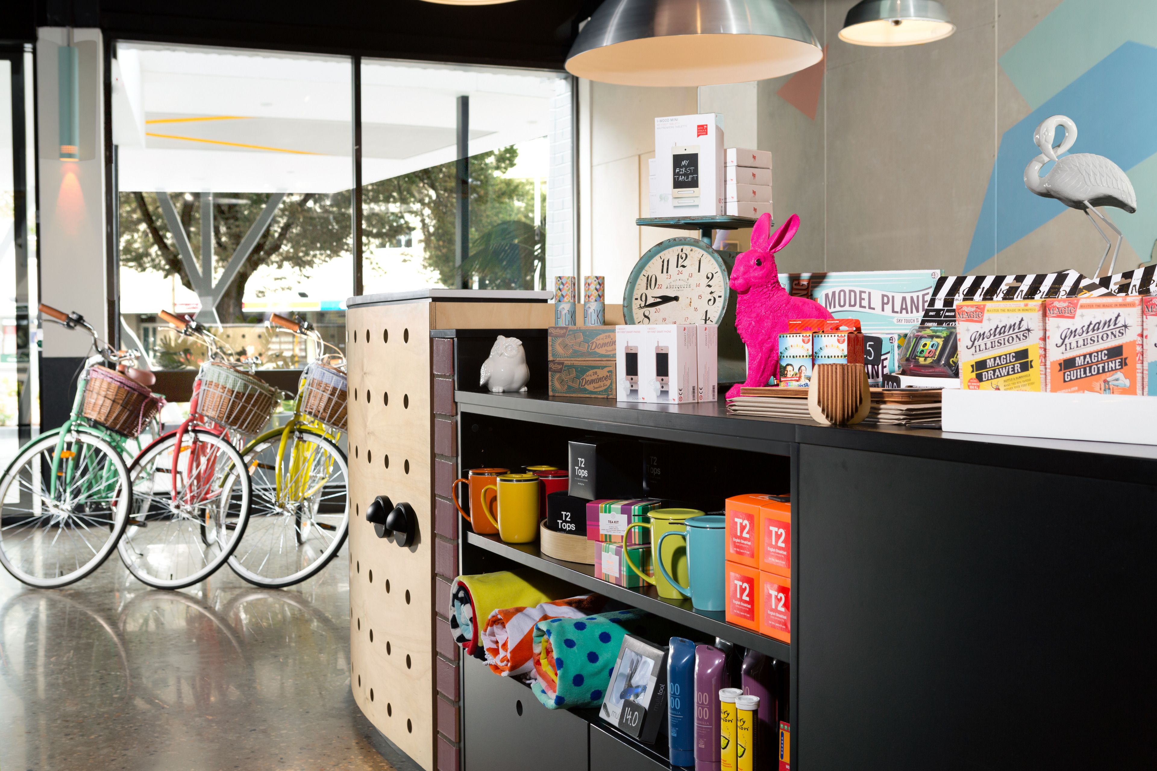 Una tienda luminosa con bicicletas, tazas coloridas y una decoración caprichosa de flamenco.