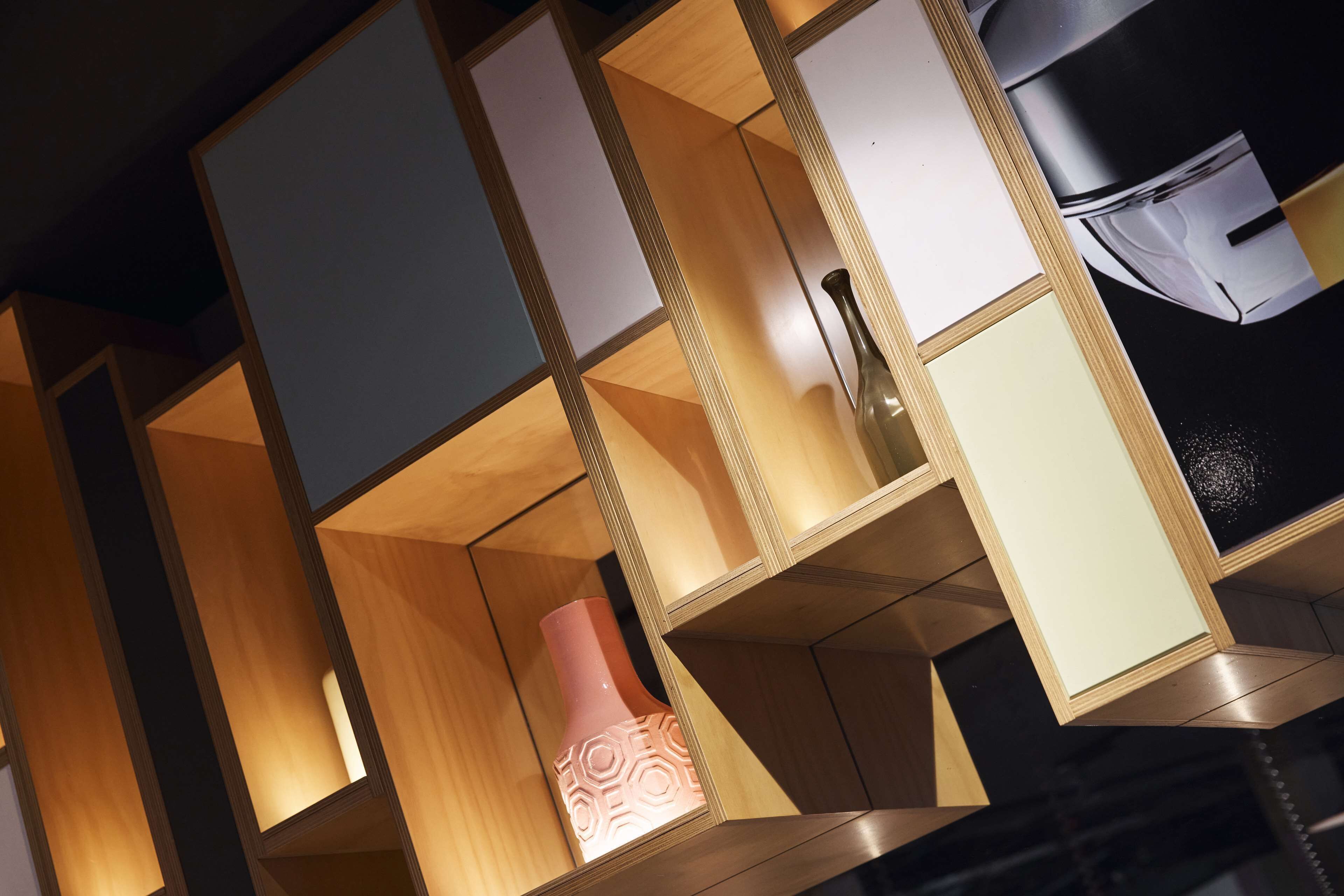 A modern interior with geometric shelving units and a decorative vase.