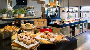 A buffet with various pastries and baked goods, a toaster, and potted plants. - Atura Albury (Albury)